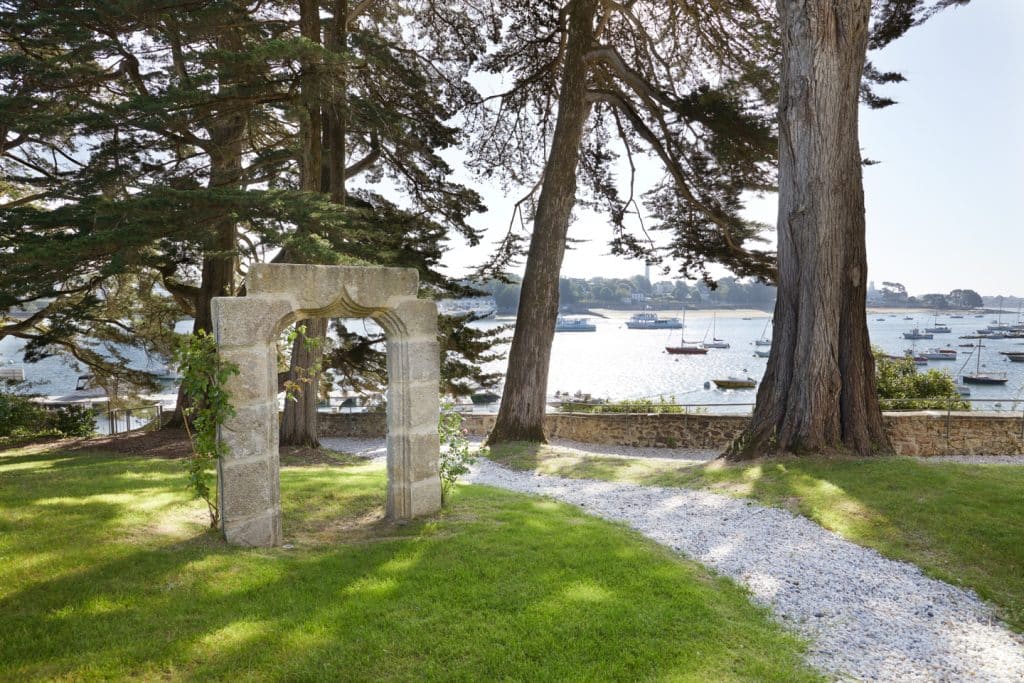 arche en granite servant de support pour des rosiers