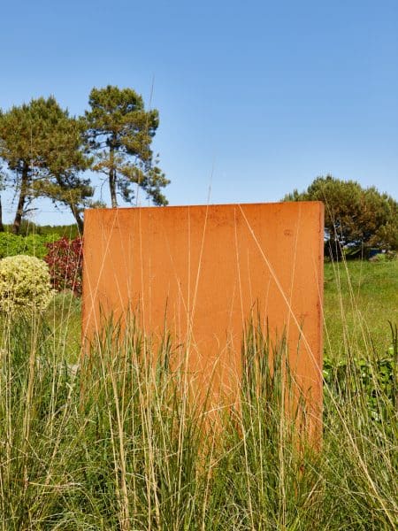 brise vue en corten avec graminées devant
