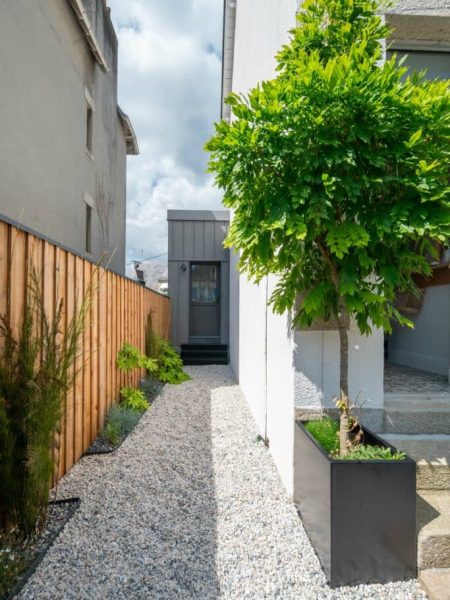 côté d'un jardin de ville avec une glycine dans un bac alu, claustra en bois